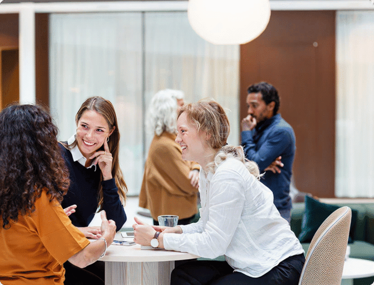 Människor som deltar i professionella nätverk och samtal vid ett företagsevenemang eller en workshop och visar prov på teamwork och kommunikationsförmåga.